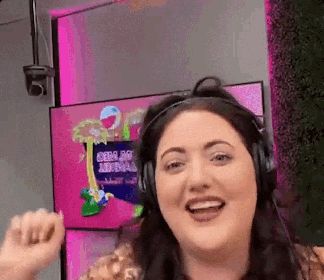 a woman wearing headphones is smiling in front of a screen that says girl go aerial