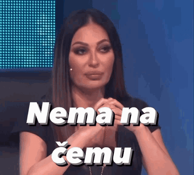 a woman is sitting in front of a sign that says nemana cemu