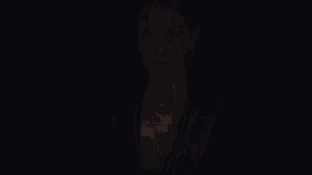 a woman wearing a black jacket and gold necklace looks at the camera