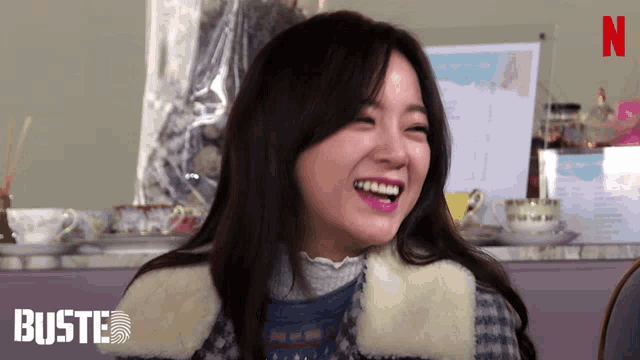 a woman laughs in front of a netflix logo