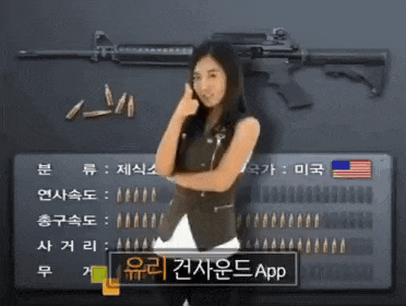 a woman is standing in front of a rifle with bullets and a sign that says ' app ' on it