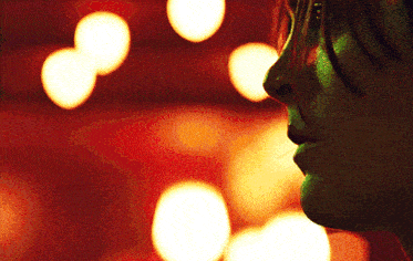 a close up of a person 's face in front of a red background