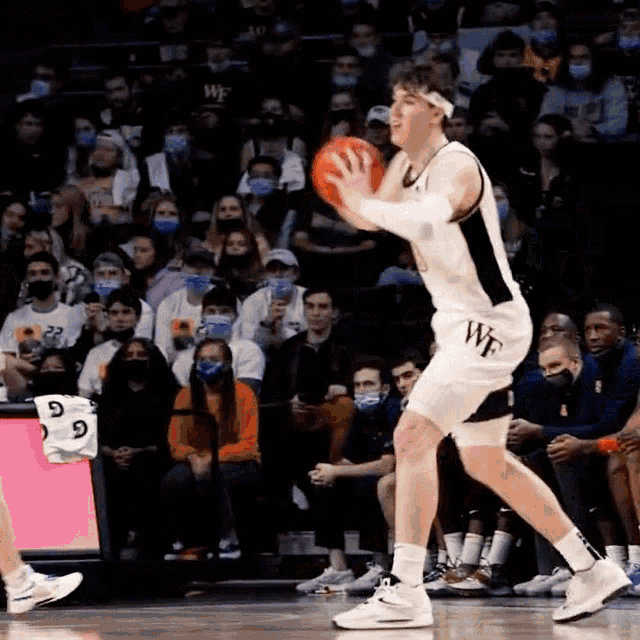 a basketball player wearing a white jersey with the word wf on it
