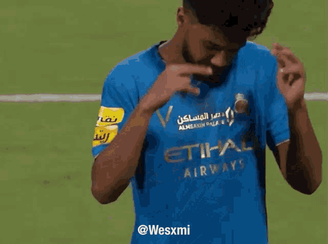 a soccer player wearing a blue etihad airways shirt