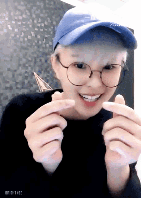 a young man wearing glasses and a blue hat with the number 255 on it