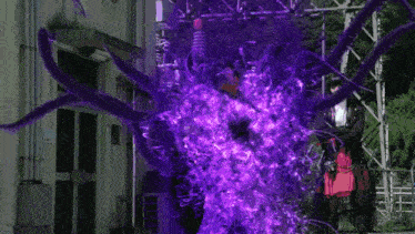 a person is standing in front of a blue and purple light