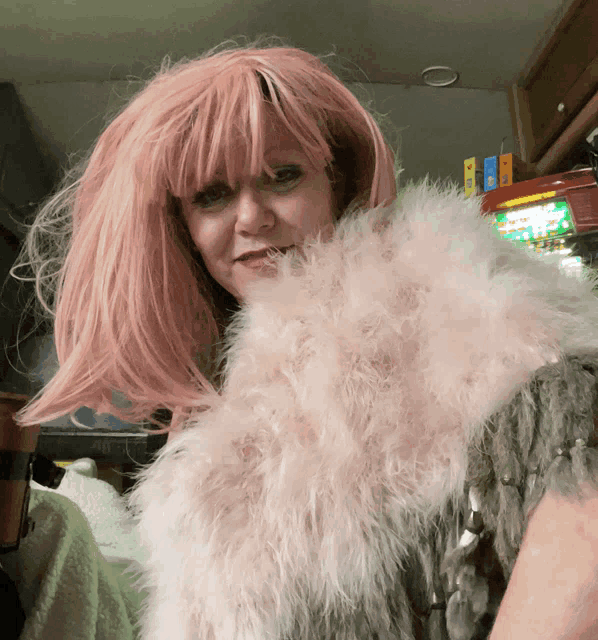 a woman wearing a pink wig and a fur stole