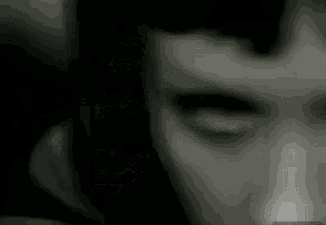 a close up of a woman 's face with glowing eyes in a dark room .