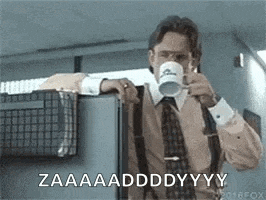 a man in a suit and tie is drinking a cup of coffee while leaning against a refrigerator .