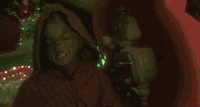 a grinch is screaming in a sleigh with a telephone in the background