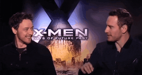 two men are standing in front of a x-men poster