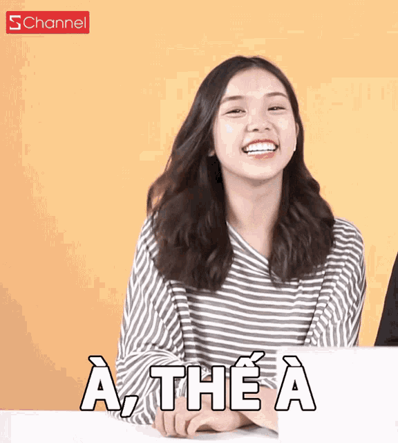 a woman sitting at a table with a sign in front of her that says a the a
