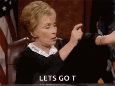a judge is sitting in a courtroom giving a thumbs up and says `` lets go t '' .