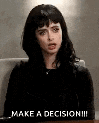 a woman is sitting at a table and making a face while saying `` make a decision ! ''
