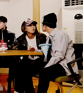 a group of people are sitting at a table with the word channie written on the wall behind them