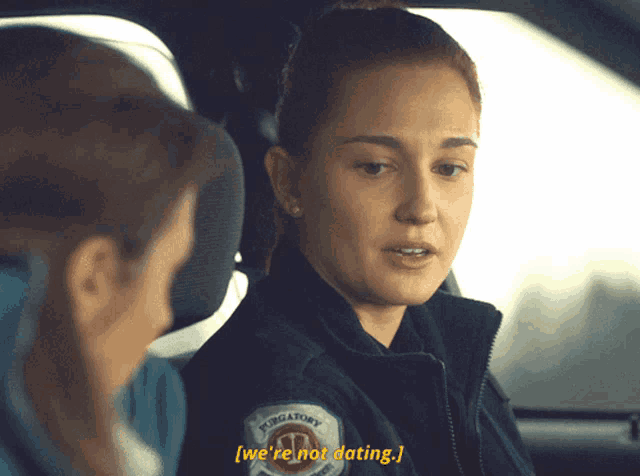 a woman in a purgatory jacket talks to another woman in a car