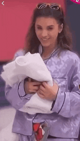 a woman in a purple pajama set is holding a white towel in her hands .
