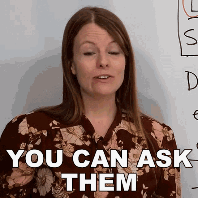 a woman says " you can ask them " in front of a white board