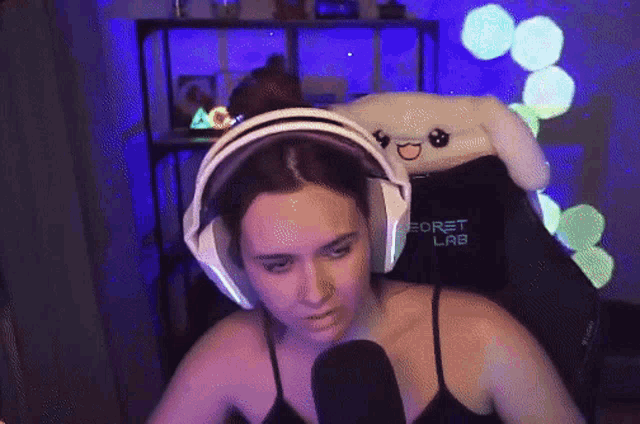 a woman is wearing headphones and sitting in a chair that says secret lab