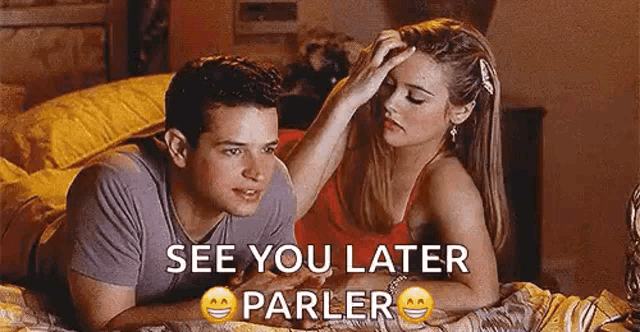 a man and a woman are laying on a bed and the woman is putting her hand on the man 's forehead .