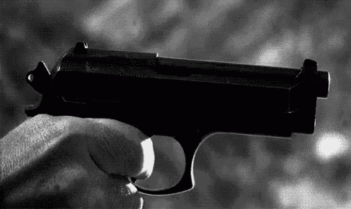 a person is holding a gun in their hand .
