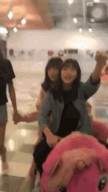 a group of girls are riding a pink pig ride