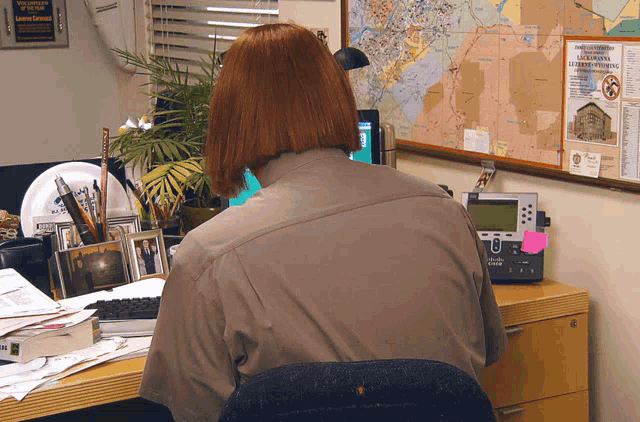 a woman sitting at a desk with a cisco phone