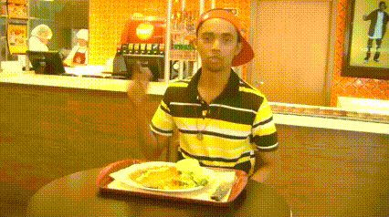 a man in a yellow and black striped shirt is holding a tray of food