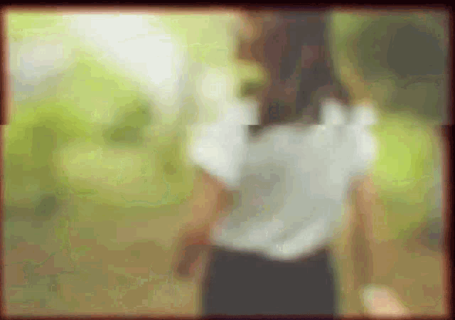 a blurry picture of a woman in a white shirt and black pants
