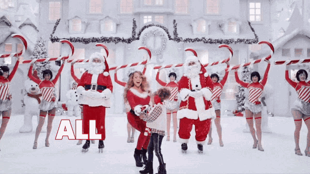 a group of people dressed in santa costumes are holding candy canes in front of a building that says all on it