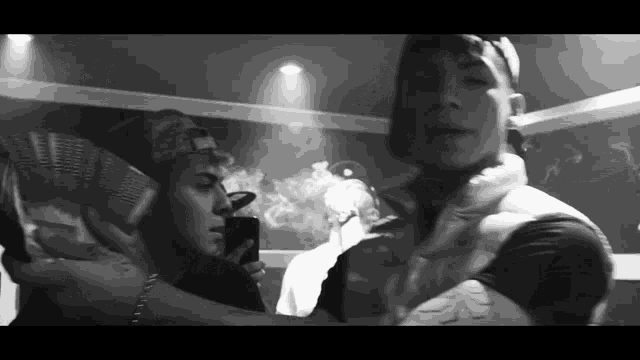 a black and white photo of a group of men smoking
