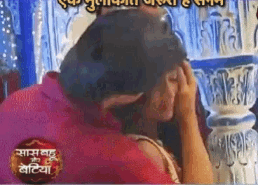 a man is kissing a woman on the forehead in front of a sign that says ' saas bahu and bhatiya '