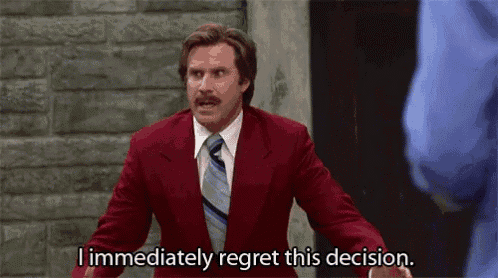 a man in a red suit and tie is talking to another man .