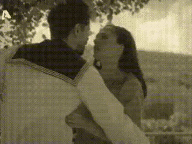 a man and a woman are hugging and kissing in a black and white photo