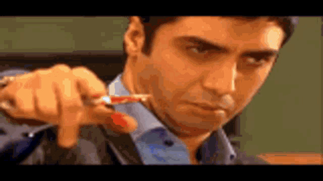 a close up of a man holding a pen in his hand