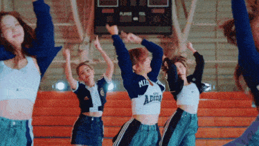a group of women are dancing in front of a scoreboard with the word player on it