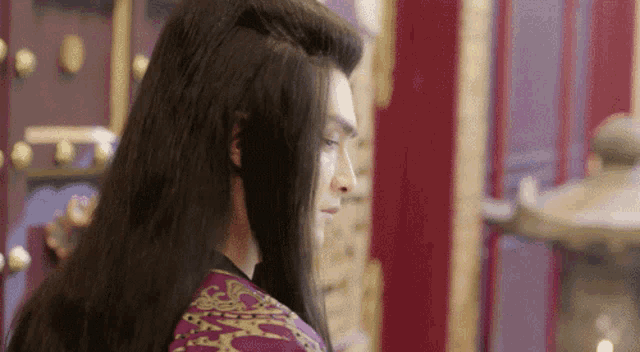 a man with long black hair is standing next to a woman with shorter hair .