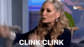 a woman is sitting on a couch with her hands outstretched and the words `` clink clink '' written on her face .