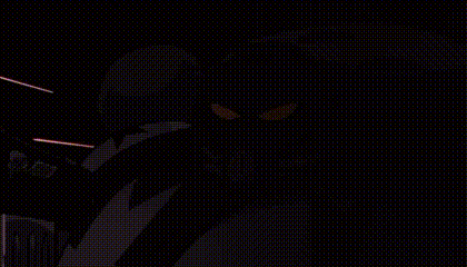 a cartoon character with red eyes is standing in front of a fire in a dark room .