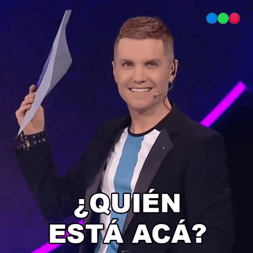 a man holding a piece of paper with the words quien esta aca