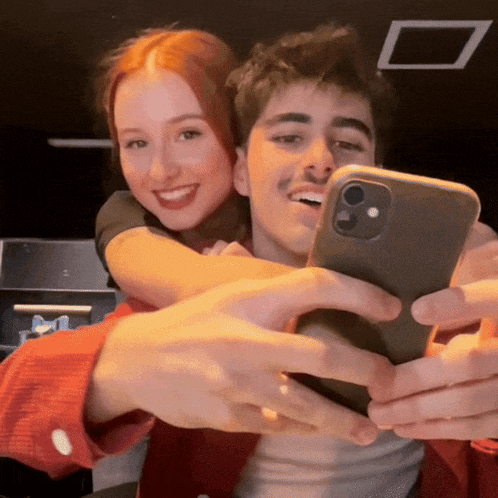 a man and woman are taking a selfie with their cell phone