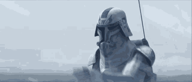 a clone trooper from star wars is holding a remote control in his hand and waving .