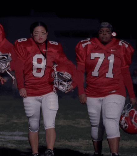 two female football players wearing red jerseys with the number 8 and 71