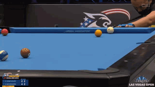 a pool table with a predator logo on the wall behind it