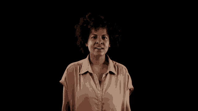 a woman with curly hair is standing in front of a black background