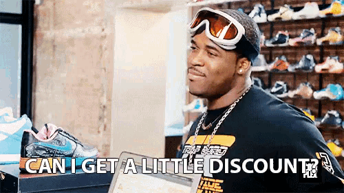 a man wearing a hat and goggles is holding a tablet and says can i get a little discount .