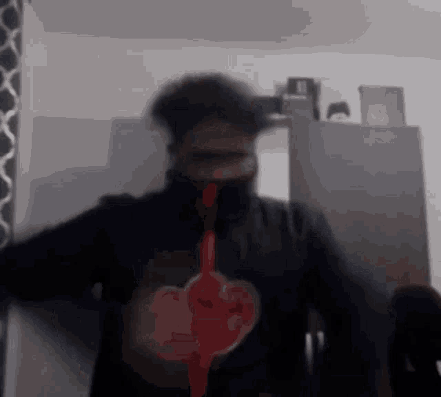 a man in a black jacket with a red heart on it