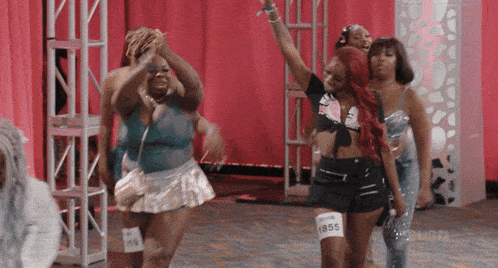 a group of women are dancing and one of them has 1855 on her shorts