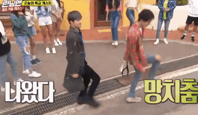 a group of people are walking down a street and one of them is dancing on the sidewalk .