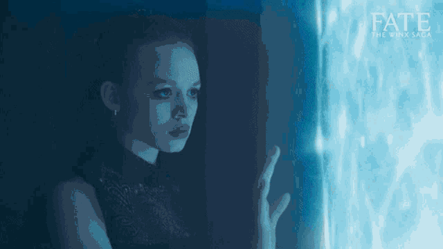 a woman in a black dress is looking out a window with the word fate above her